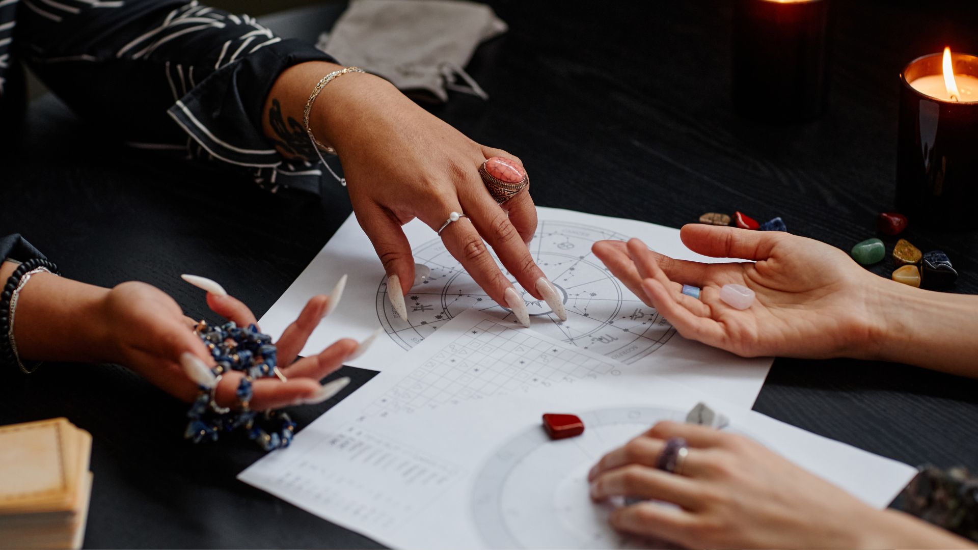 A group of people sitting around a table with their hands on a piece of paper