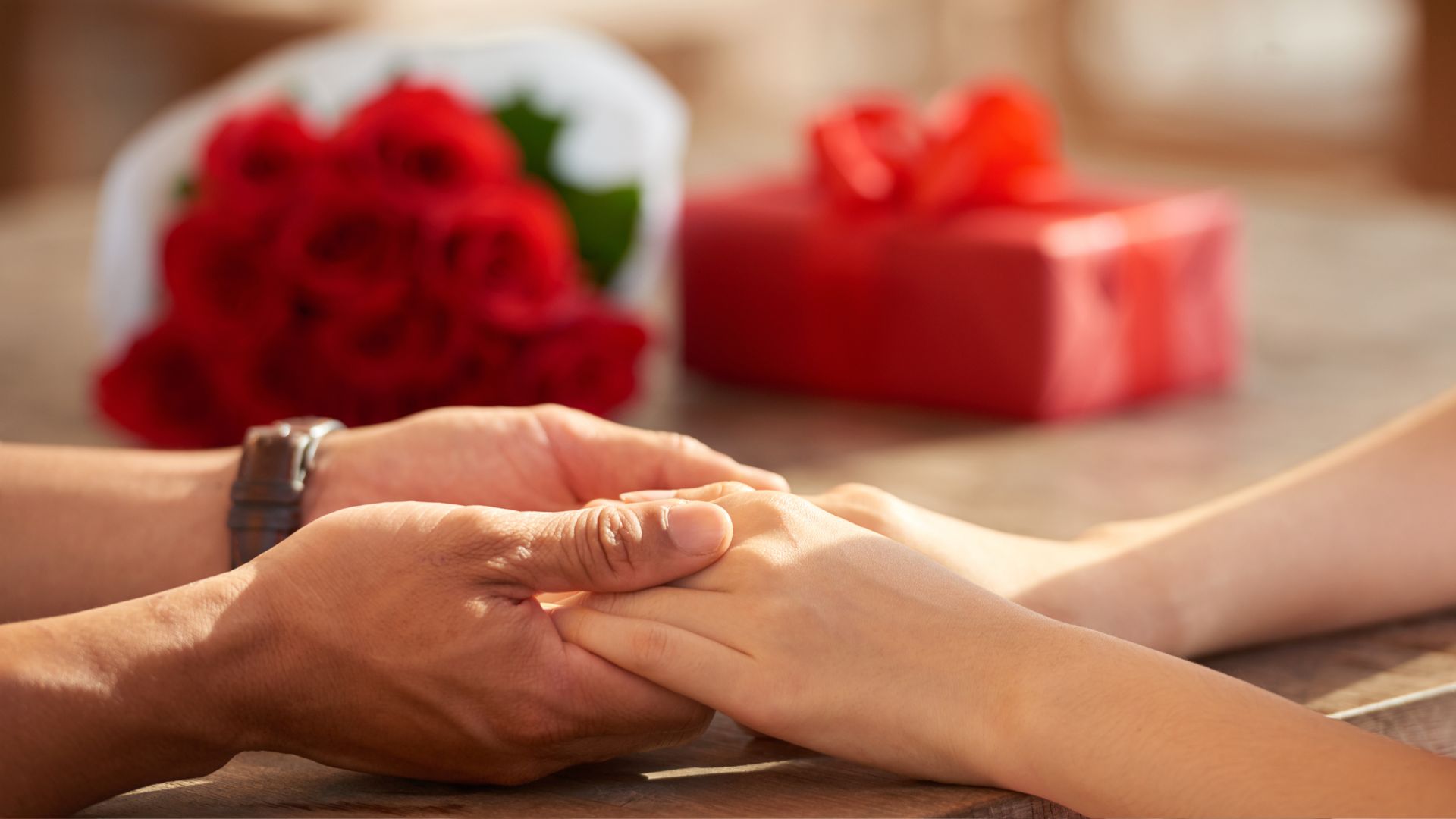 A man and a woman holding hands over a table