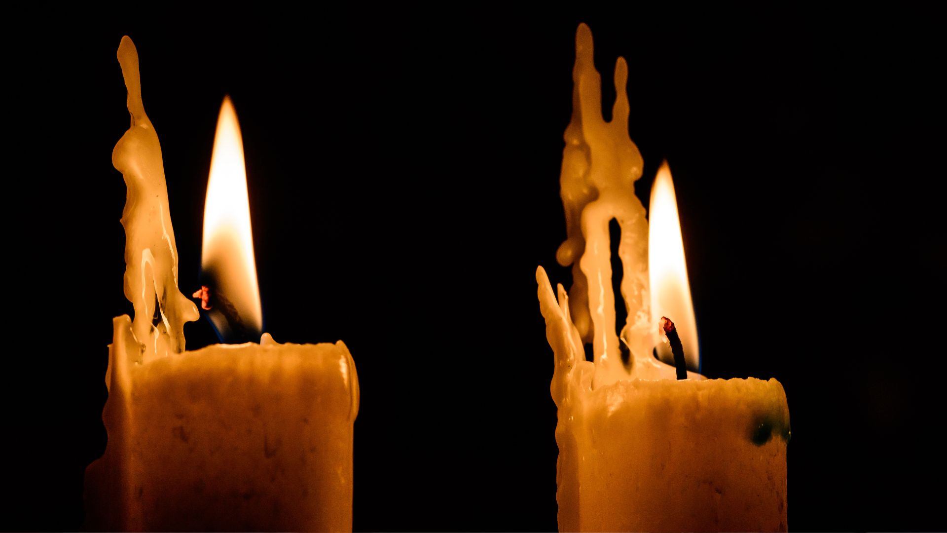 A couple of candles that are lit up in the dark