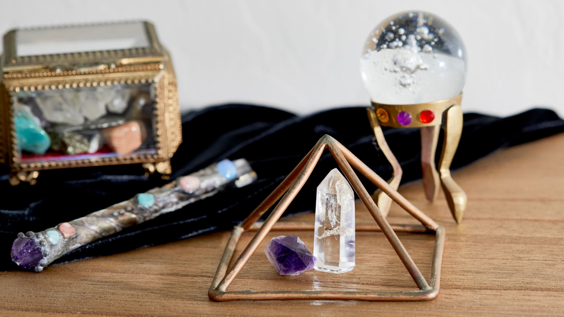 A wooden table topped with a crystal ball and other items